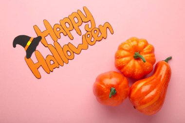 Pembe arka planda balkabaklarıyla Cadılar Bayramı kompozisyonu. Üst görünüm.