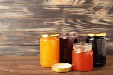 Kahverengi arka planda, fotokopi alanı olan reçel çeşitleri. Üst görünüm