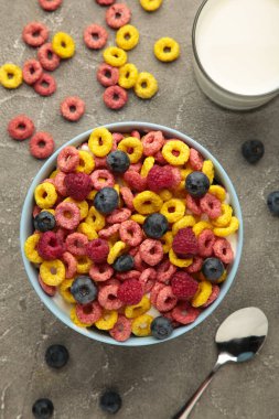 Mısır gevreğiyle kahvaltı, gri arka planda süt ve dut. Üst Manzara. Dikey fotoğraf