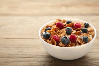 Mısır gevreğiyle kahvaltı ve gri arka planda böğürtlen. Üst görünüm.