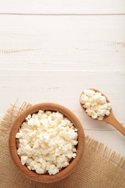 Kahvaltı için süzme peynir beyaz arka planda ahşap kasede. Üst görünüm