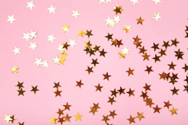 Pembe arka planda altın parıltılı yıldızlar. Üst görünüm