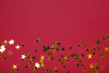 Kırmızı arka planda altın parıltılı yıldızlar. Üst görünüm