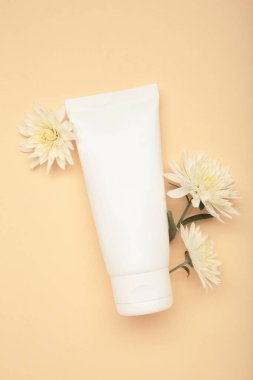 Doğal güzellik şart. Bej arkaplanda kasımpatı olan cilt kremi. Üst görünüm
