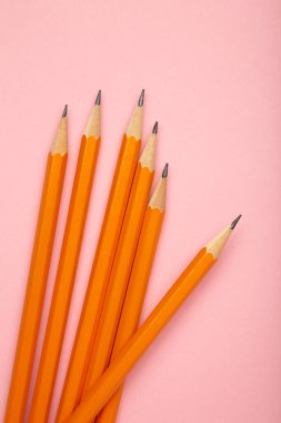 Pembe arka planda silgisi olan çizgili kalem. Okul kırtasiyesi. Üst görünüm