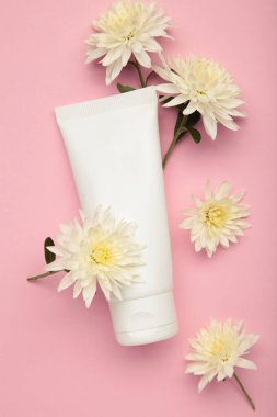 Doğal güzellik şart. Pembe arka planda kasımpatı olan cilt kremi. Üst görünüm