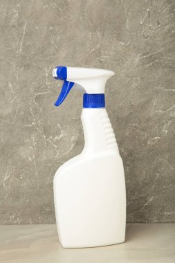 Gri beton arka planda beyaz sprey temizleme ürünü. Üst görünüm