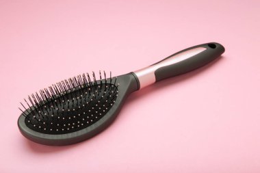 Pembe arka planda masaj saç fırçası. Mesaj için yer var. Üst görünüm