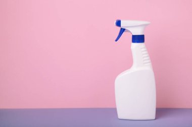 Pembe arka planda beyaz sprey temizlik ürünü. Üst görünüm