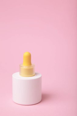 Pembe arka planda minimalist beyaz kozmetik damlası şişesi. Cilt bakımı, serum ya da güzellik markası sunumları için şık bir model. Üst görünüm