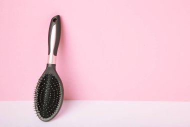 Pembe arka planda masaj saç fırçası. Mesaj için yer var. Üst görünüm