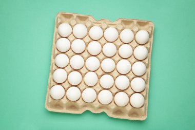 Paskalya yumurtaları karton kutuda, arka planda en az stil kompozisyonu. Üst görünüm