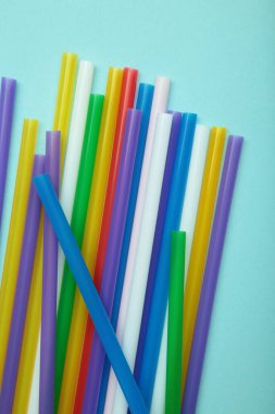 Renkli plastik pipeti mavinin üzerine koy. Dikey fotoğraf