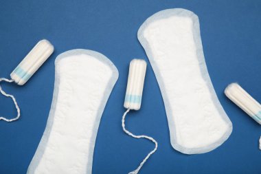 Mavi arka planda regl pedi ve tampon. Üst görünüm