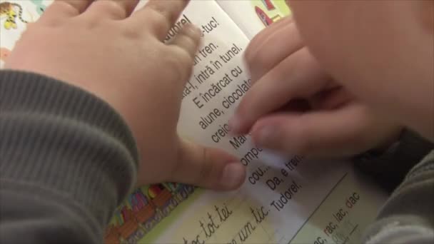 Ребенок читает книгу по слогам — стоковое видео