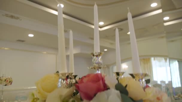 Κηροπήγιο διακοσμημένο με λουλούδια σε ένα γιορτινό τραπέζι σε ένα πολυτελές δωμάτιο — Αρχείο Βίντεο