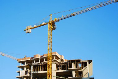 İnşaat sahasının arka planı. Çok katlı binanın yanında vinç var. Endüstriyel geçmiş. 96745354
