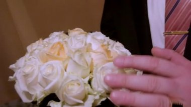 Damat gelin buketi düzeltiyor. bir yüz