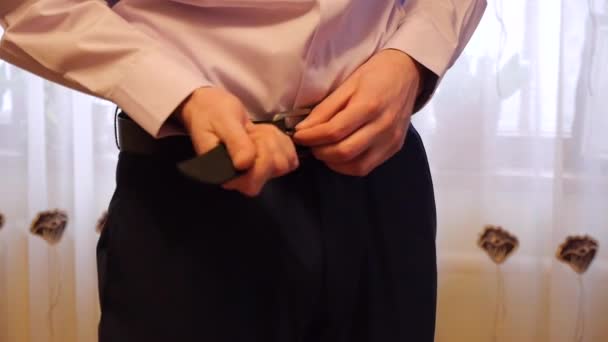 Man (the groom) buttons on the trousers belt — Stock Video