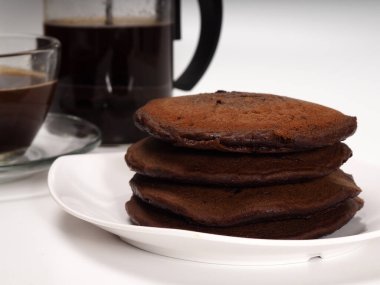 İzole edilmiş beyaz bir arka planda istiflenmiş kahverengi çikolatalı krep yakın çekim