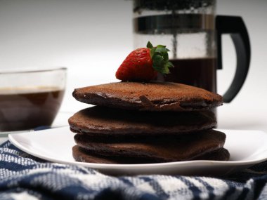 İzole edilmiş beyaz bir arka planda istiflenmiş kahverengi çikolatalı krep yakın çekim