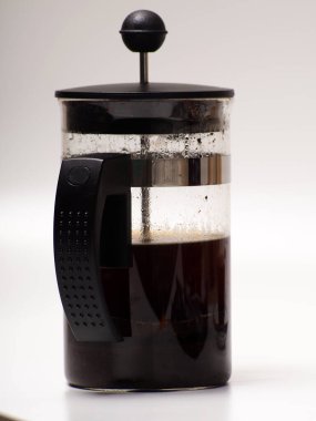 Bir fincan kahve ve Fransız presi beyaz izole bir arka planda.