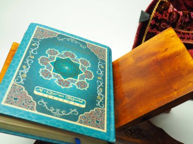 Kutsal Kur 'an' ın resmi ahşap bir masada, beyaz izole bir arka planda çekiliyor.