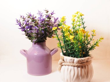 Seramik vazoda suni plastik çiçek resmi. İzole edilmiş beyaz arkaplanda çekim yap