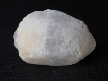 Beyaz değerli taşın yakın çekimi. Siyah desenli bir arkaplanda çekim yap