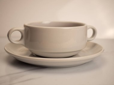 Beyaz arka planda beyaz bir porselen kase ve tabağın resmi