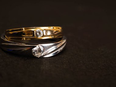 Siyah arka planda güzel elmaslar olan altın alyansı yakın çekim