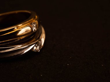 Siyah arka planda güzel elmaslar olan altın alyansı yakın çekim