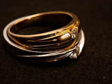 Siyah arka planda güzel elmaslar olan altın alyansı yakın çekim