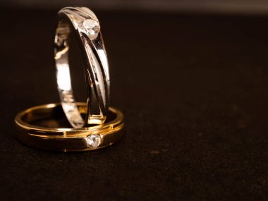 Siyah arka planda güzel elmaslar olan altın alyansı yakın çekim