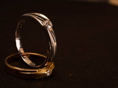 Siyah arka planda güzel elmaslar olan altın alyansı yakın çekim