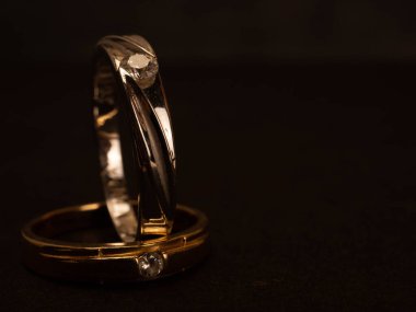 Siyah arka planda güzel elmaslar olan altın alyansı yakın çekim