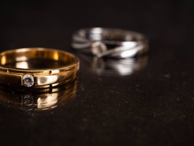 Siyah arka planda güzel elmaslar olan altın alyansı yakın çekim