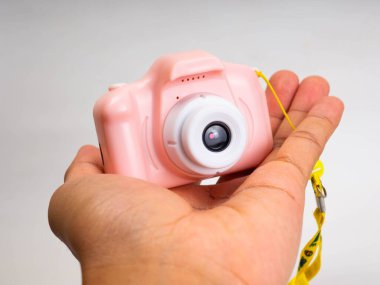 Beyaz arka planda pembe bir kamera oyuncağı.