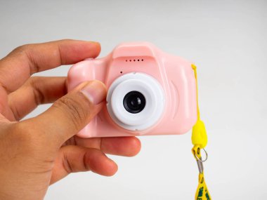 Beyaz arka planda pembe bir kamera oyuncağı.