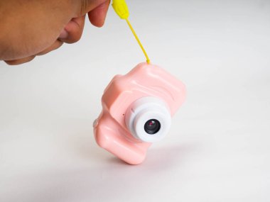 Beyaz arka planda pembe bir kamera oyuncağı.