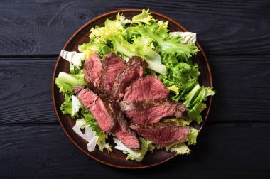 Kızarmış biftekli salata. Ahşap arka planda