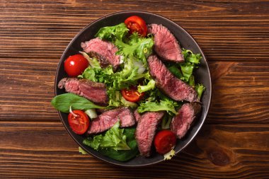 Kızarmış biftekli salata. Ahşap arka planda