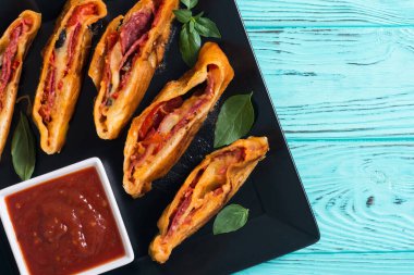 İtalyan yemeği peynirli, salamlı, zeytinli ve domatesli pizza. 