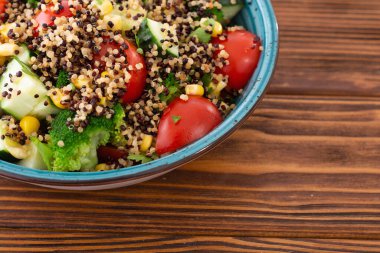 Kinoa brokoli, salatalık, domates ve mısırlı taze sebze salatası.