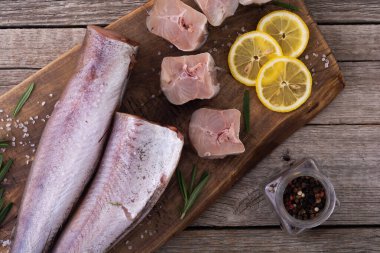 Ahşap arka planda çiğ hake. Yemek yapmaya hazır.