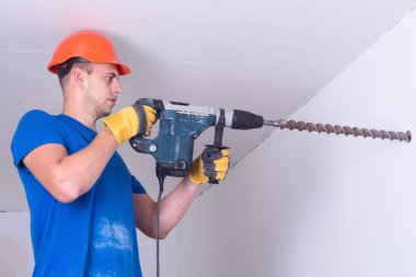 Elektrikli matkap ile görevli genç tamirci