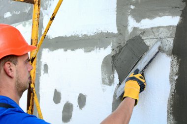 Harç üzerinde köpük yalıtım yayılan işçi