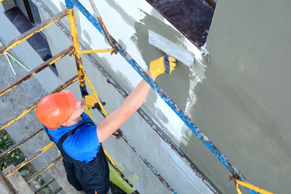 Worker spreading mortar over styrofoam insulation — Stock Photo, Image