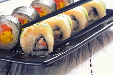 Suşi ahşap arka planda yuvarlanıyor.