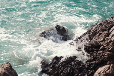 Sert okyanus dalgalarının kayalık bir kıyıya çarptığı dramatik bir manzara.